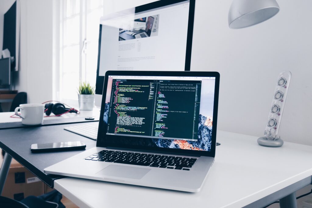 a computer on a desk with software open in an IDE