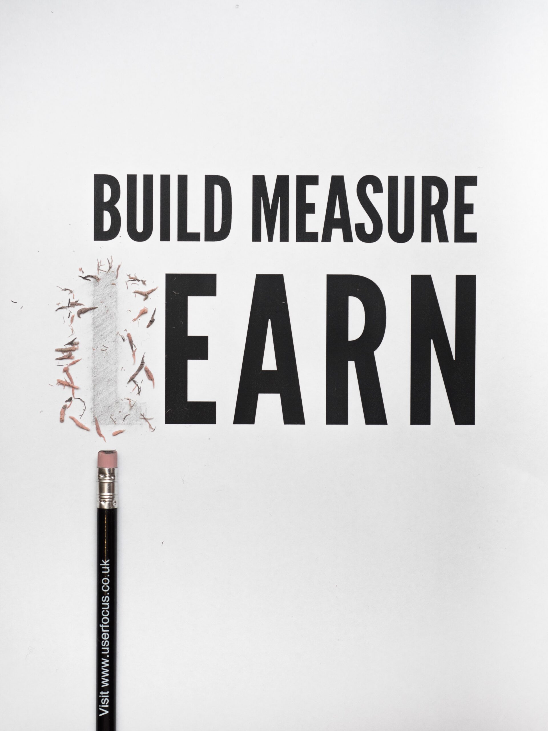 Build measure learn written on paper with the L in learn erased by a pencil